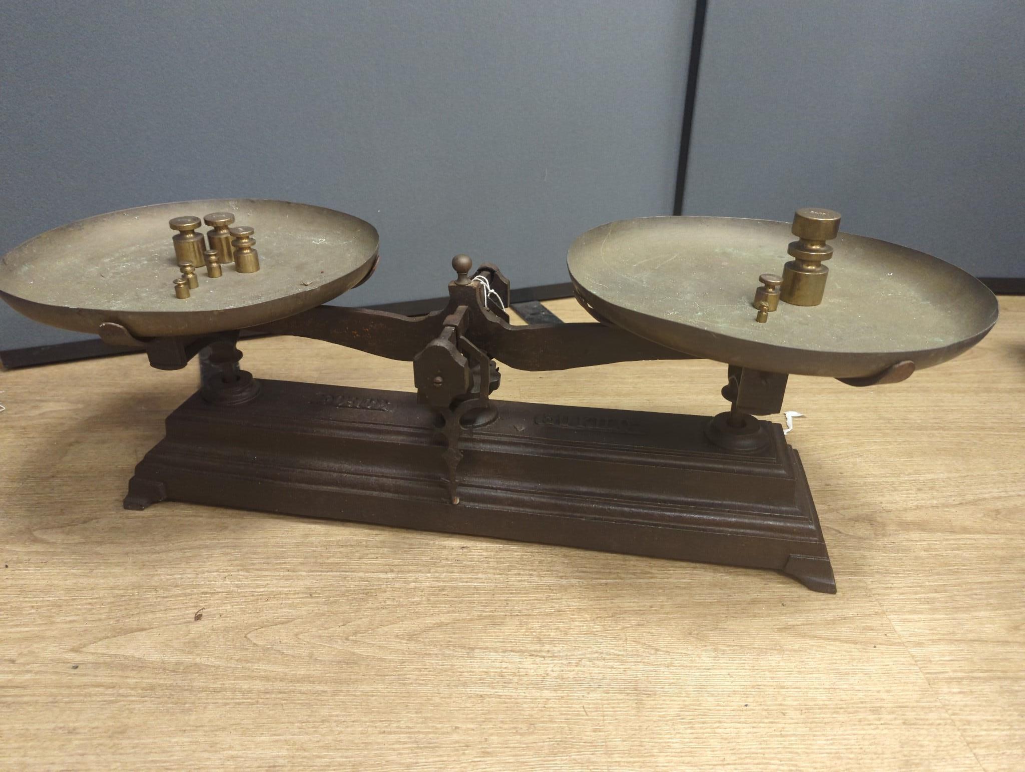 A large French cast iron and brass weighing scale, 82 cms wide.